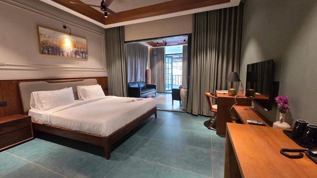 a hotel room with a bed and a desk and a desk at Mango Lantern Villa by Mirth, Kollam in Perumanseri