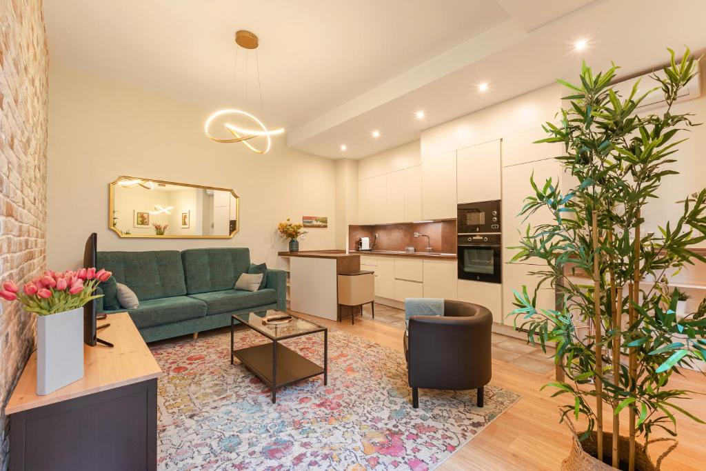 a living room with a green couch and a kitchen at Fasquel Center in Seville