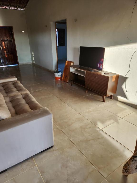 a living room with a couch and a flat screen tv at Casa por do sol Flecheiras in Flecheiras