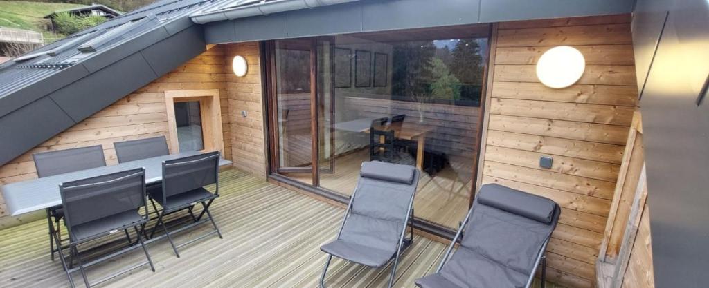 阿邦当斯Appartement Neuf 4 Pièces的享有甲板上的景色,配有椅子和桌子