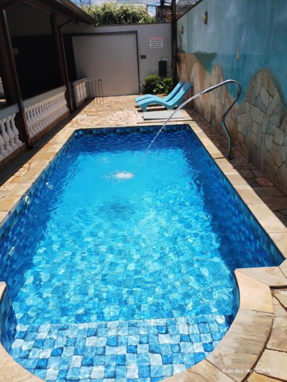 a swimming pool with blue tiles on the floor at Casa com piscina in Ribeirão Preto