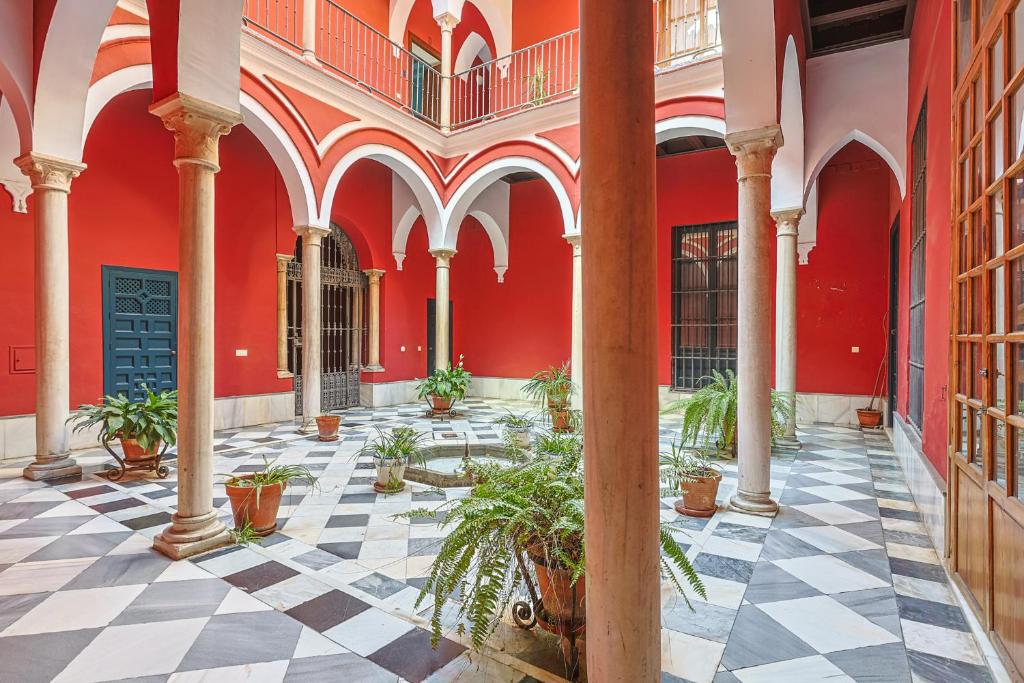 a courtyard of a building with potted plants at Casa Palacio Guiomar by SHS in Seville