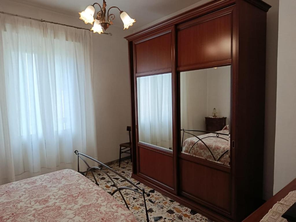 a bedroom with a large wooden cabinet with a mirror at La Villetta in Vittorito