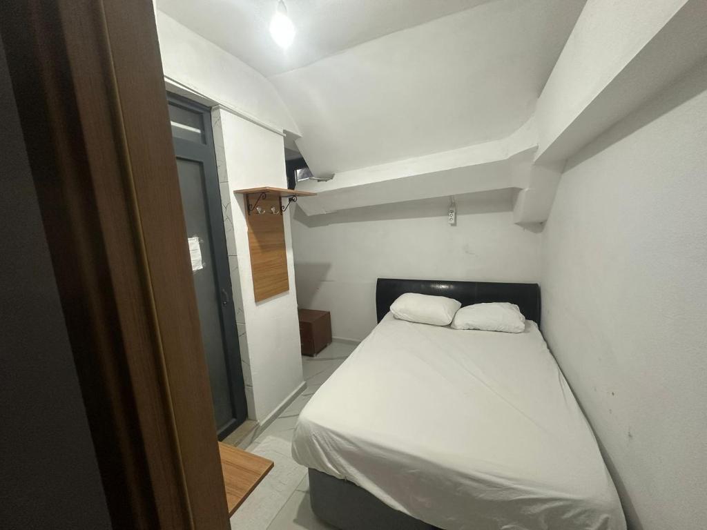 a small room with a bed with two white pillows at NR1 Pansiyon in Canakkale