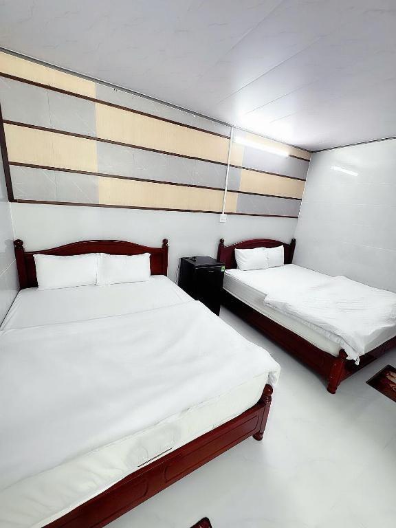 two beds in a small room with twothirdsessions at Khách sạn Vinh Hotel in Thốt Nốt