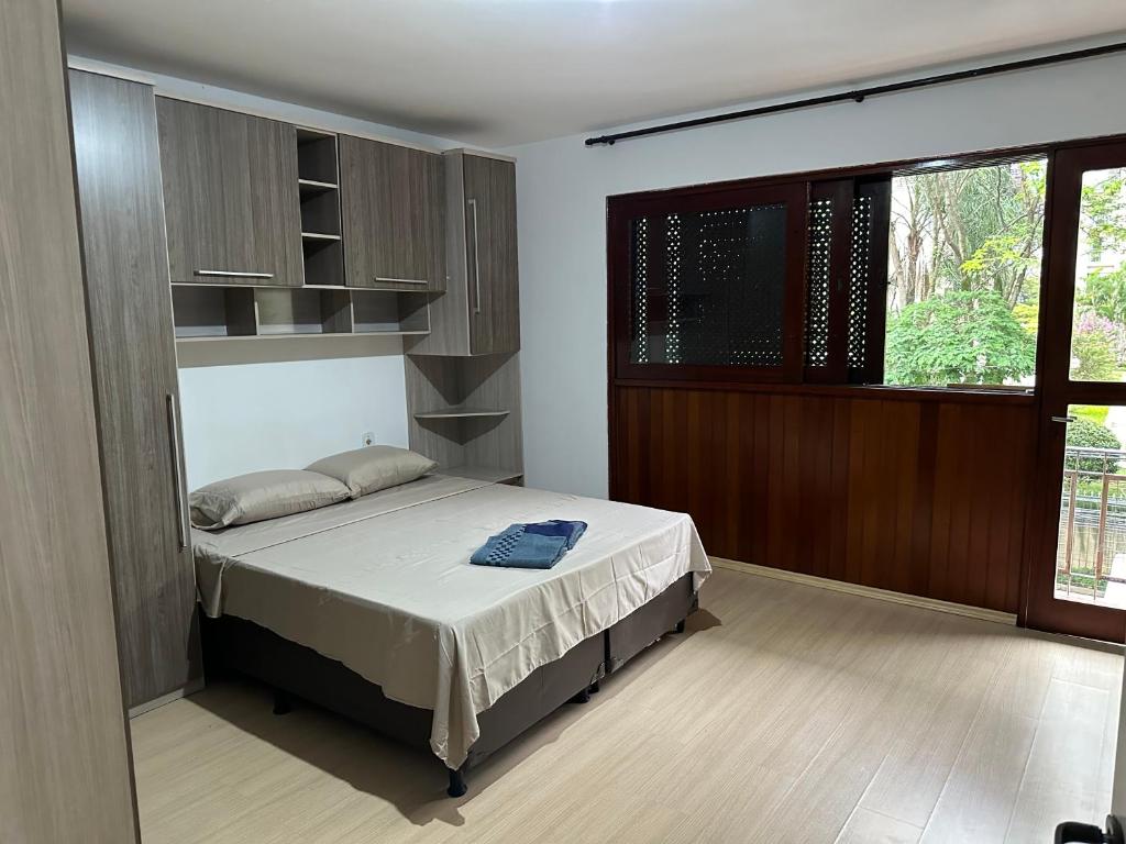 a bedroom with a bed and a large window at Quartos Vila Olímpia 1 in Sao Paulo