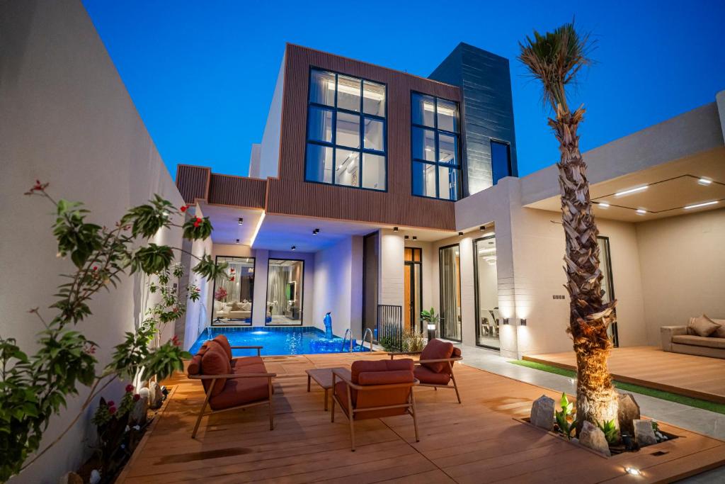 a house with a palm tree and a pool at شاليه مسا الفندقي in Buraydah