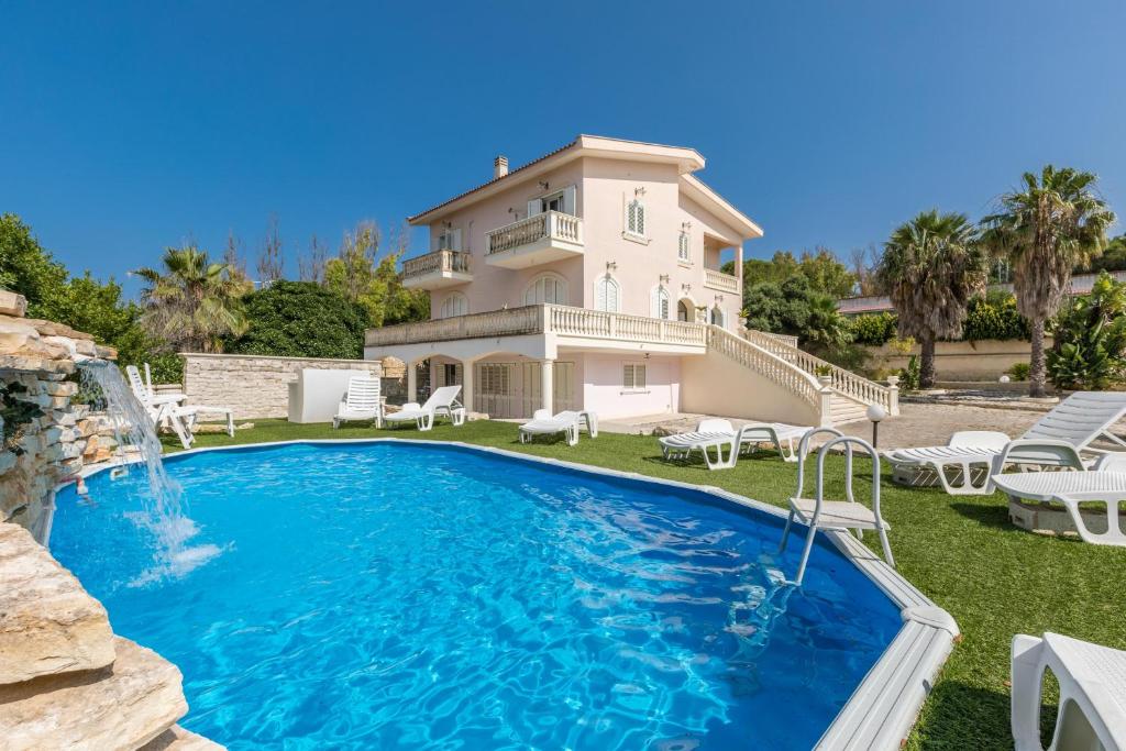 a large house with a swimming pool in front of it at La Villa Alba by BarbarHouse in Leporano Marina