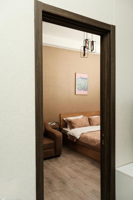 a bedroom with a bed and a mirror at HD Didveli Apartment in Bakuriani