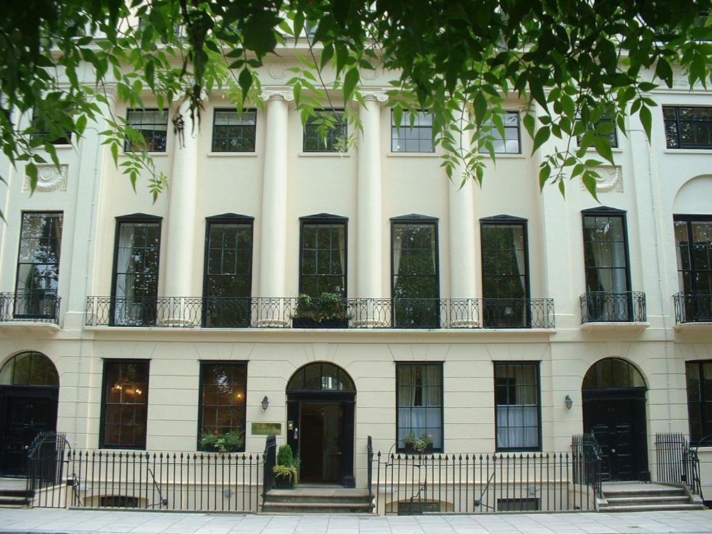 a large white building with windows and a door at The Goodenough Hotel London in London