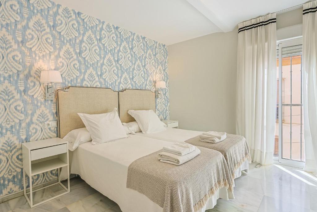 a bedroom with a bed and a blue and white wall at San Clemente House in Seville