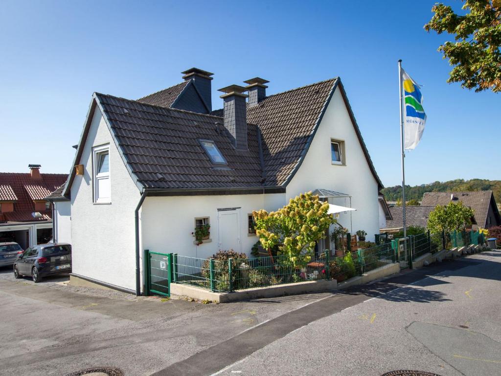 een groot wit huis met een zwart dak bij Ferienwohnung Studio Casa in Delecke