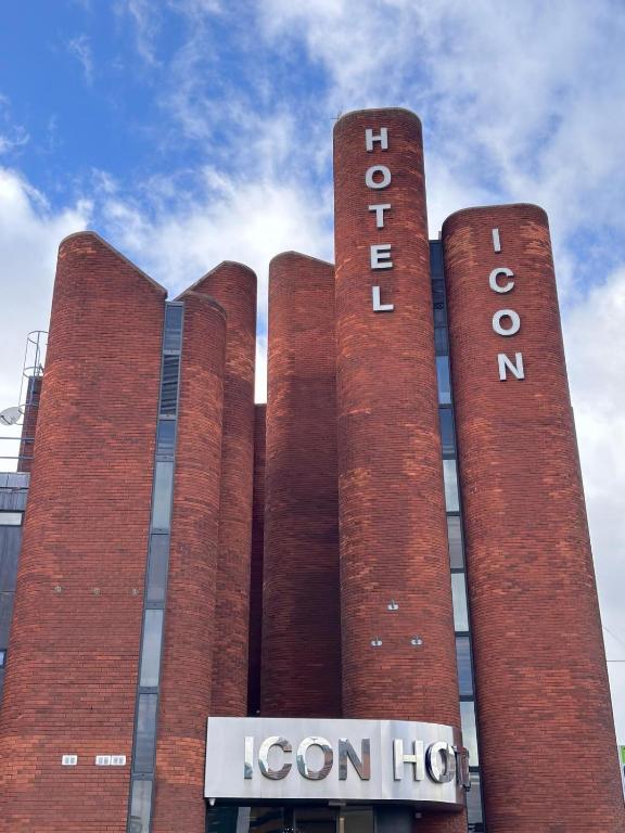 a building with three tall red brick towers at ICON Hotel in Luton