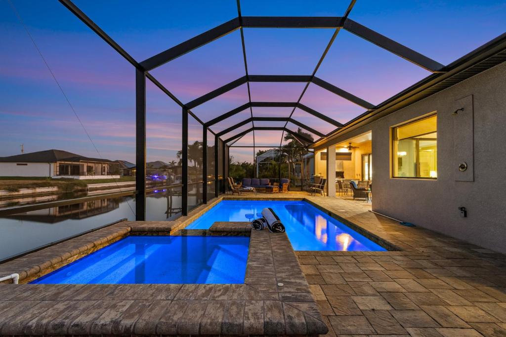 ein Haus mit einem Swimmingpool mit Dach in der Unterkunft The Pink Flamingo Sanctuary in Cape Coral