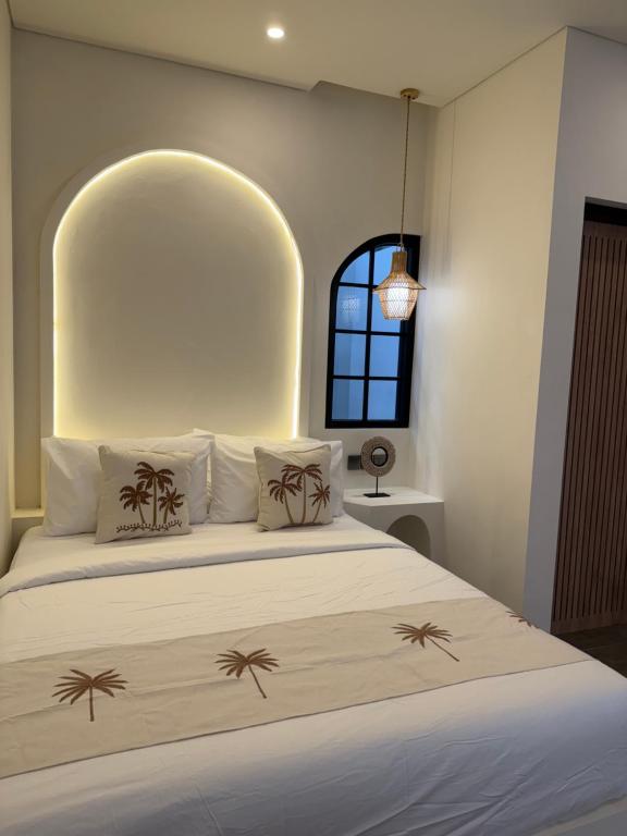 ein Schlafzimmer mit einem Bett mit Palmen darauf in der Unterkunft Amigo uluwatu in Uluwatu