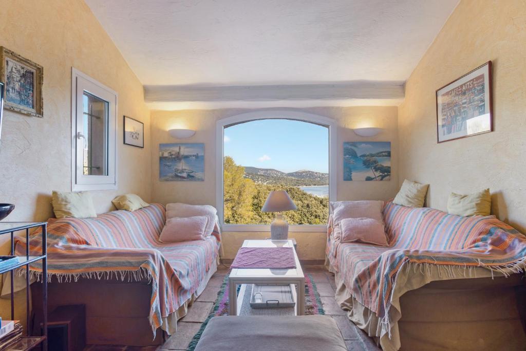 Villa - La Mignonette في كافالير سور مير: غرفة معيشة مع أريكتين ونافذة كبيرة