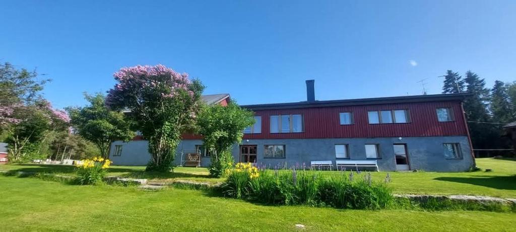 a house with a green yard in front of it at Mission Guesthouse in Gäddnäs