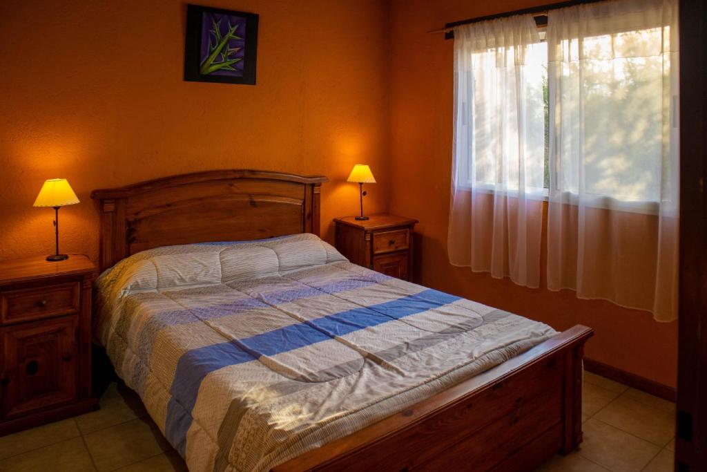 a bedroom with a bed and two lamps and a window at Cabañas en Nono La Soñada in Nono