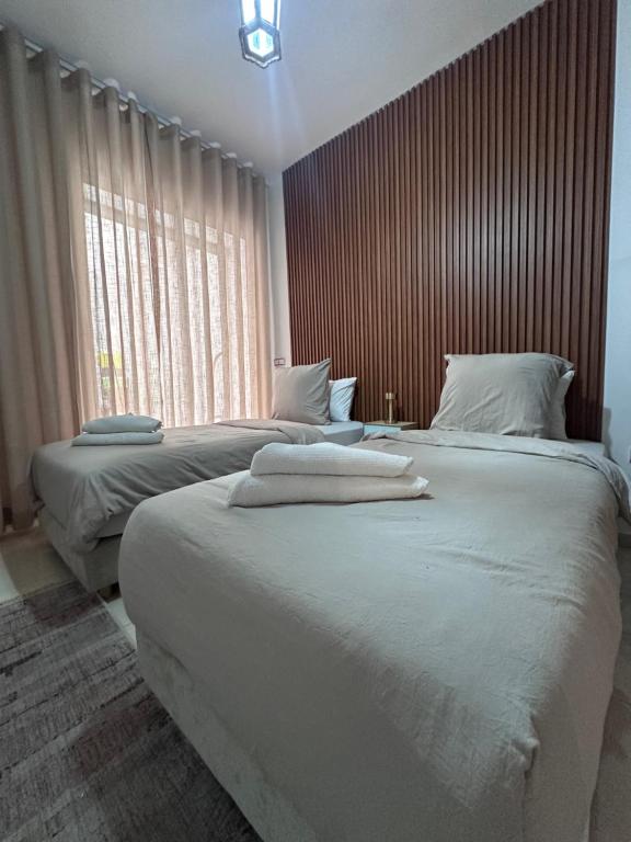 a bedroom with two beds with white towels on them at BlueBreak Aourir in Aourir