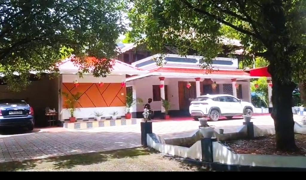 a white car parked in front of a house at ETERNA Homestay Rackad in Mūvattupula