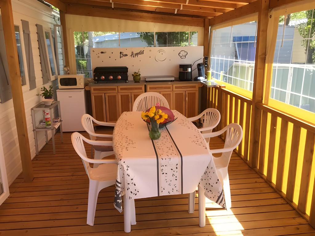 einen Tisch mit einer Blumenvase auf einer Veranda in der Unterkunft Location Mobilhome Agde in Agde