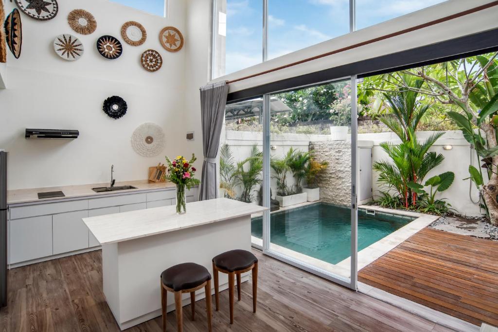 une cuisine avec une île et une piscine dans l'établissement Center of Canggu - cute little villa - calm & quiet, à Canggu