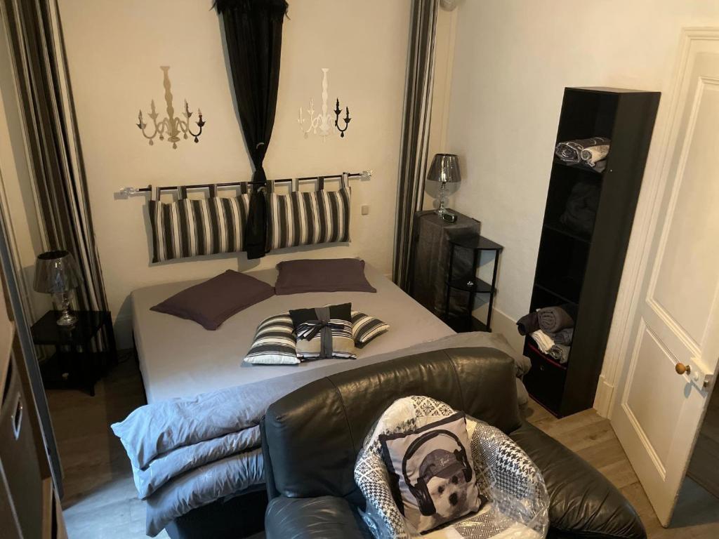 a bedroom with a bed and a leather couch at Appartement Au Quai 1921 in Besançon