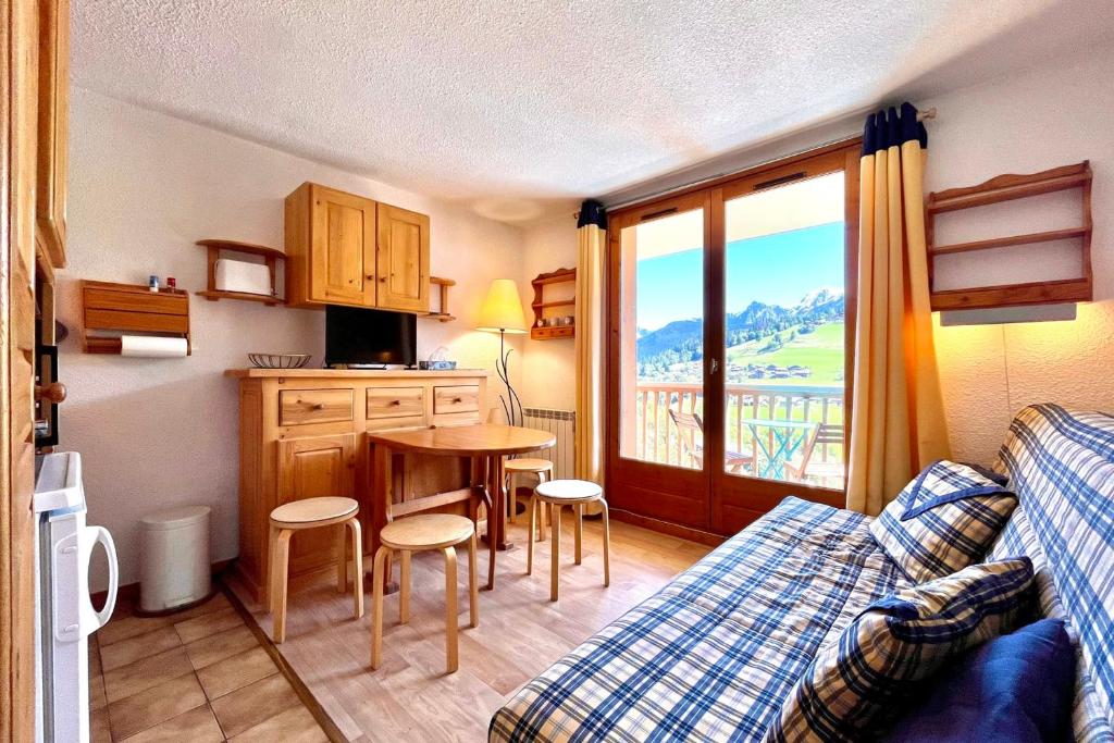 een woonkamer met een bank en een keuken met een tafel bij Bright apartment with Mont Blanc view in Combloux