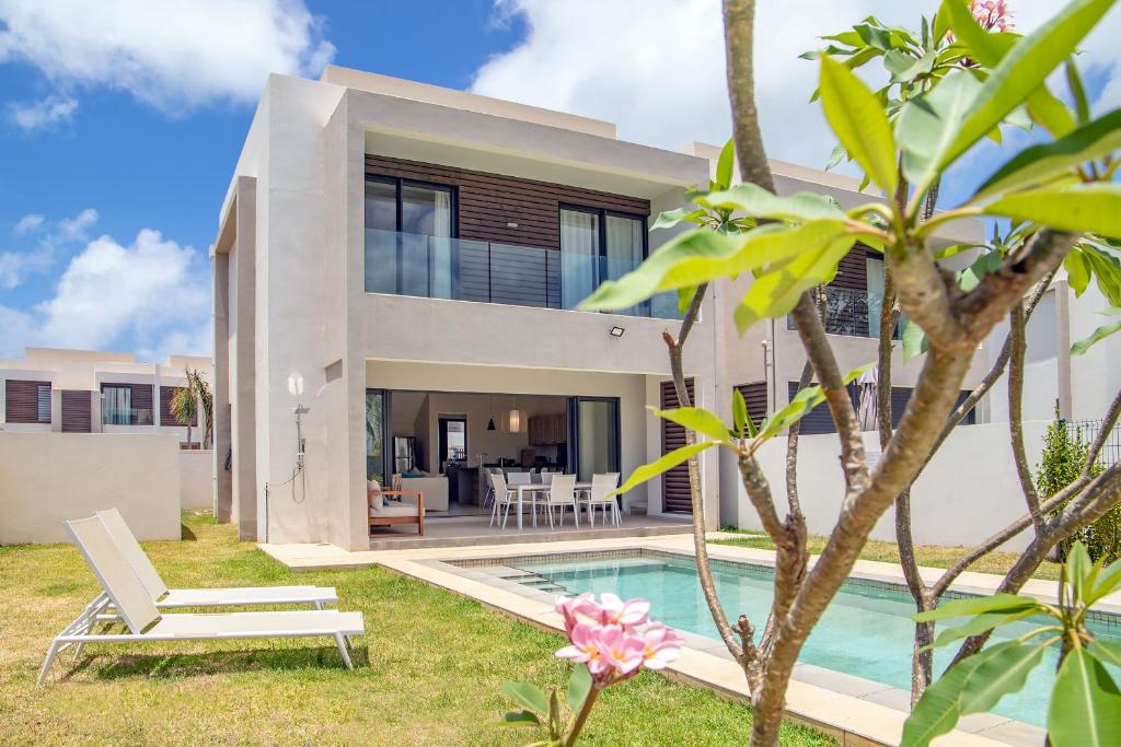 a villa with a swimming pool and a house at Serenity Pool Villa at Azuri in Roches Noires