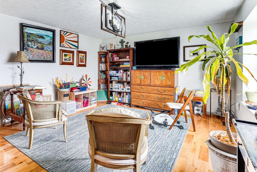 a living room with a tv and a table and chairs at Near Trails, Parks and Orchards Germantown Retreat in Germantown