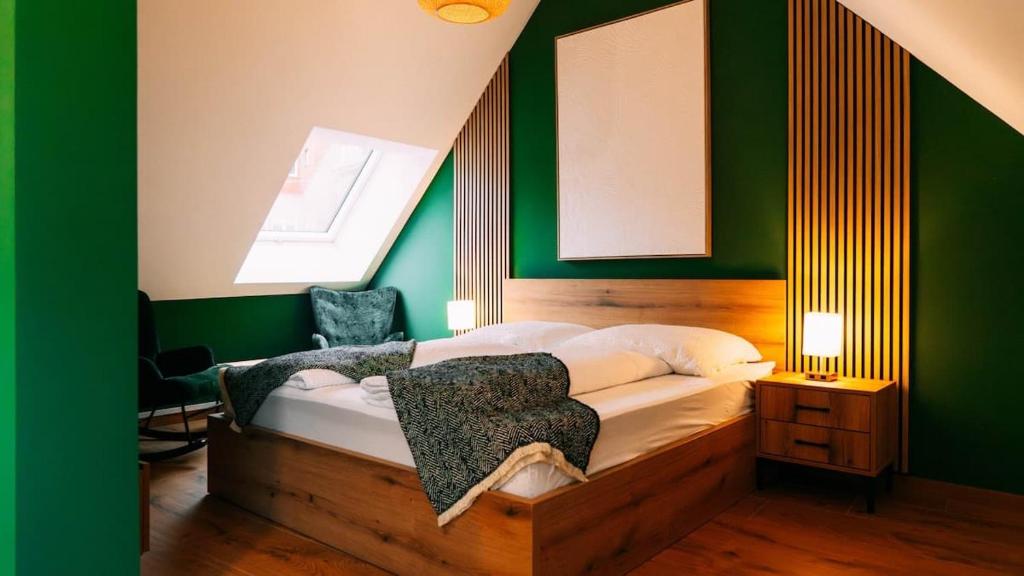 Schlafzimmer mit einem Bett mit grünen Wänden und einem Fenster in der Unterkunft Evergreen Cozy Apartment im Herzen von Durlach in Aue