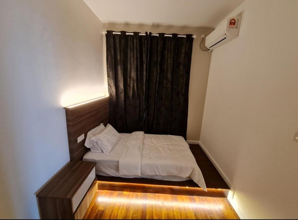 a small bedroom with a bed and a black curtain at Lucky 7 Homestay - Utama Court in Sandakan