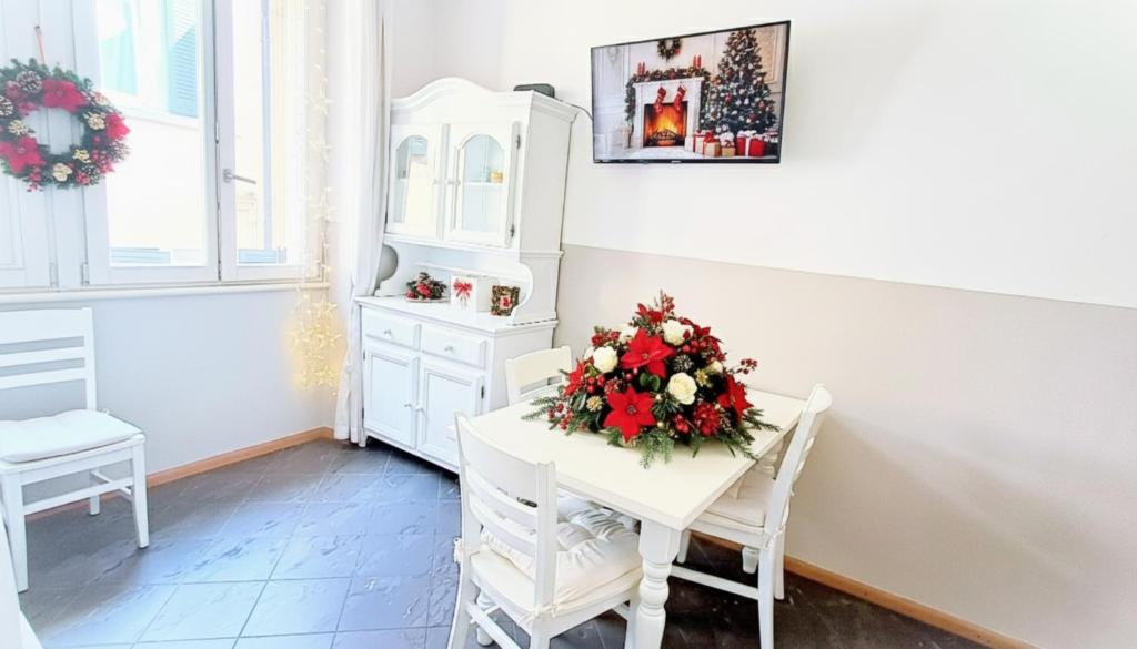 a white room with a table with flowers on it at Strategico tra i MERCATiNi di Natale! zona centro storico - stazione in Trento