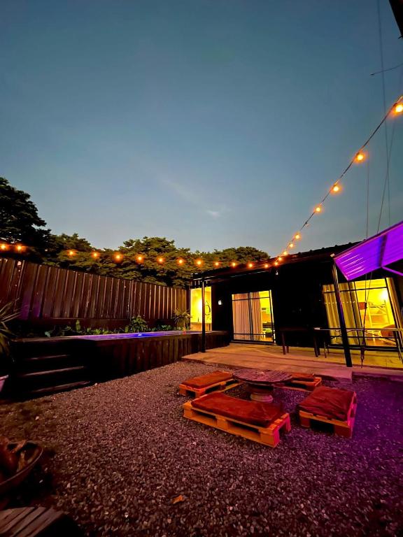 a patio with tables and lights on a building at Boxify Cabins in Alingaro