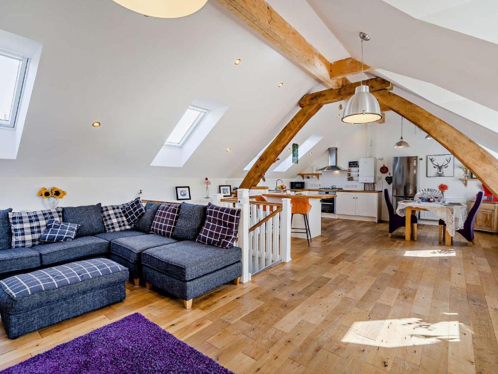 Una sala de estar con un sofá azul y una cocina. en 1 Bed in North Queensferry 96221, en Inverkeithing