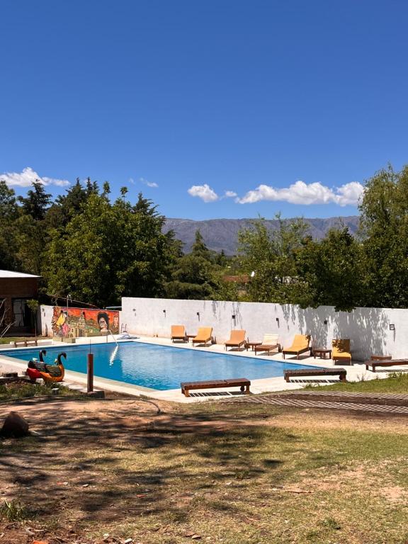 a swimming pool with lounge chairs at Apart La Ideal in Villa Cura Brochero