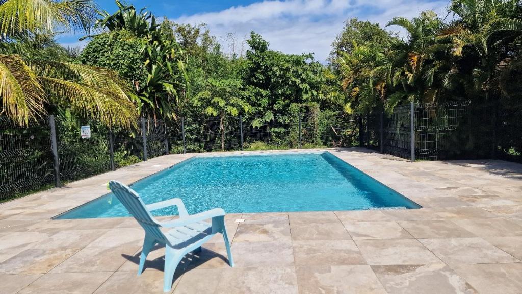 ein Stuhl neben einem Swimmingpool in der Unterkunft Refuge tropical entre mer et nature à Sainte-Rose Guadeloupe in Sainte-Rose