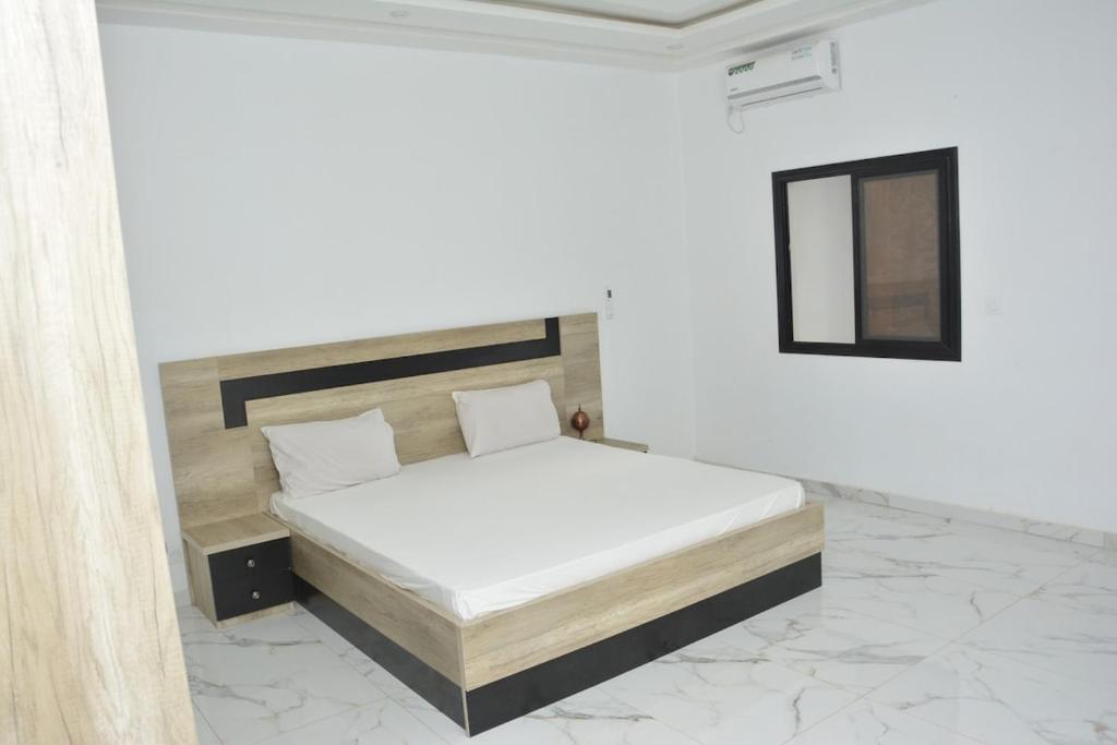 a bedroom with a bed in a white room at Beautiful Modern Villa in Mbour