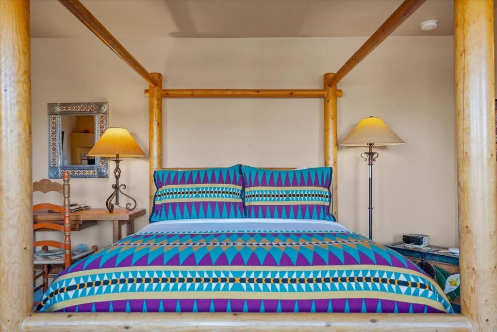 a large bed with colorful pillows in a bedroom at Adobe Hacienda - Baja Suite in Oak Creek