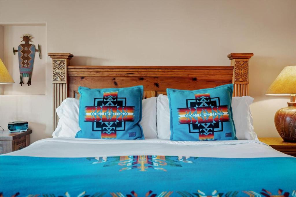 a bedroom with a bed with blue pillows at Adobe Hacienda- Sedona Suite in Oak Creek