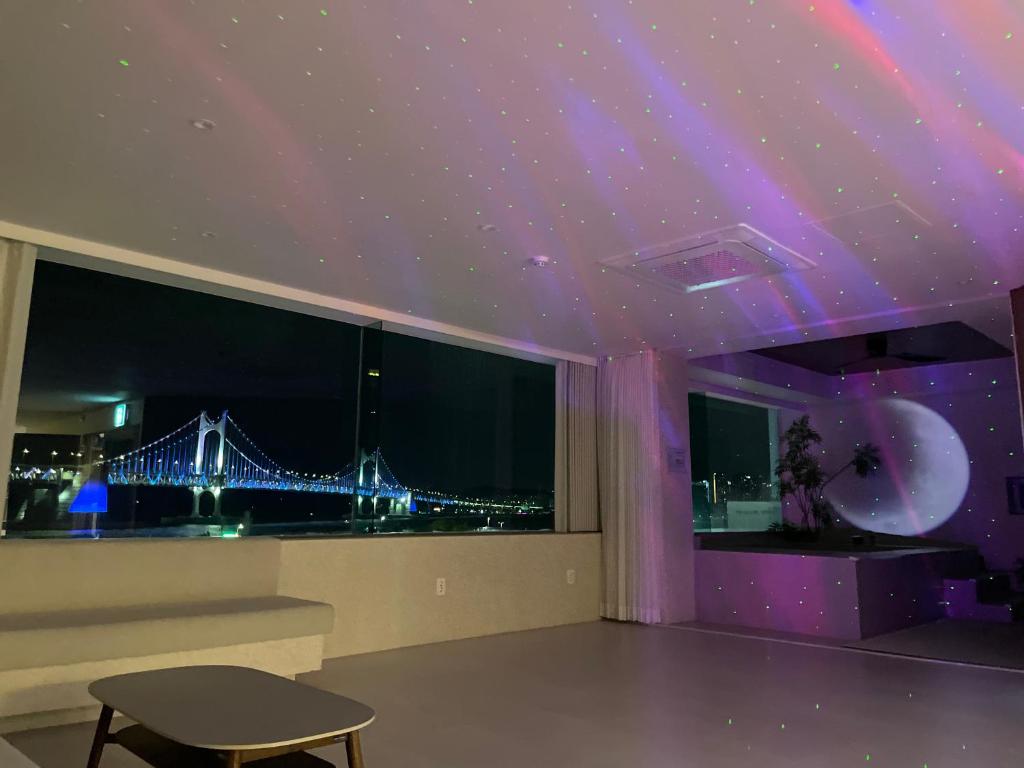 Ein Zimmer mit violetter Decke und Blick auf eine Brücke in der Unterkunft 광안사계스테이 GwanganSagyeStay in Busan