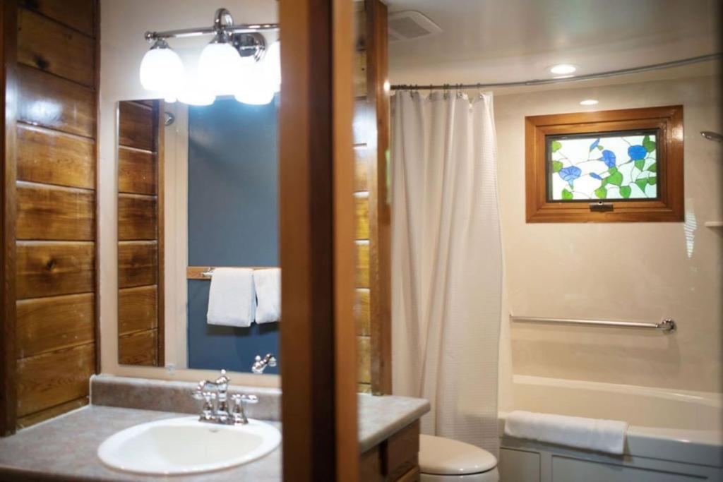 a bathroom with a sink and a toilet and a shower at MORNING GLORY - Cabin for 2 in Oak Creek in Indian Gardens