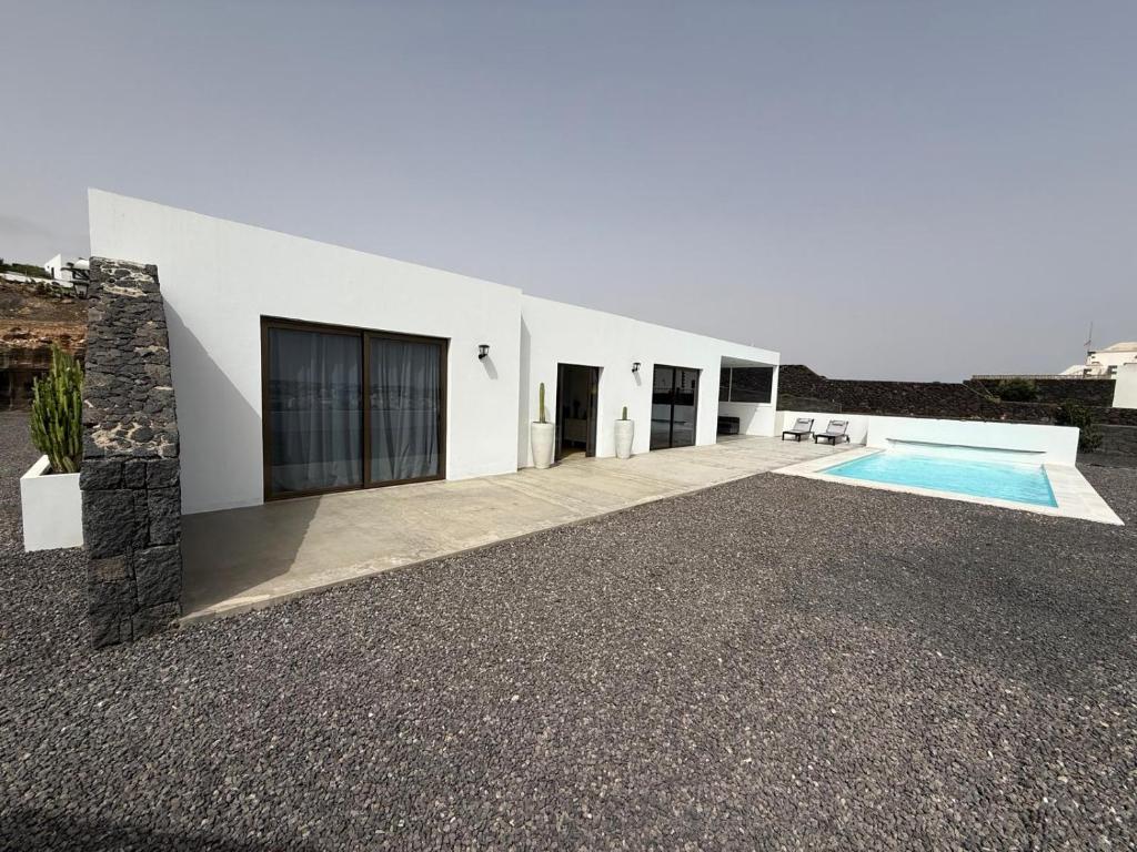a white building with a swimming pool in front of it at Casa Jable Mozaga in Mozaga