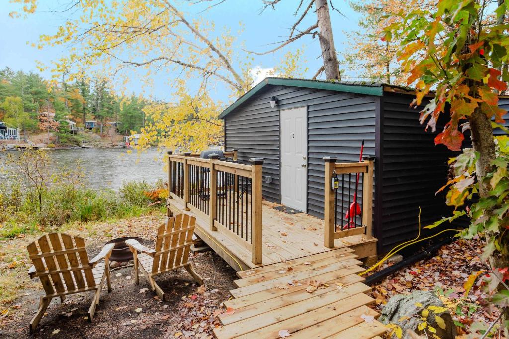 a small cabin with two chairs and a deck at Studio Cottage in Pine Lake #6 in Gravenhurst
