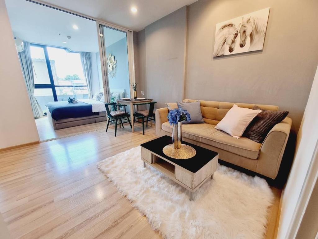 a living room with a couch and a table at Cityscape Bliss Phuket in Ban Sam Kong