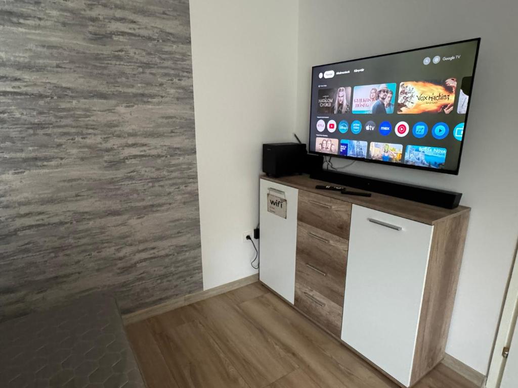 a living room with a flat screen tv on a stand at Szeged Sunshine Apartman in Szeged