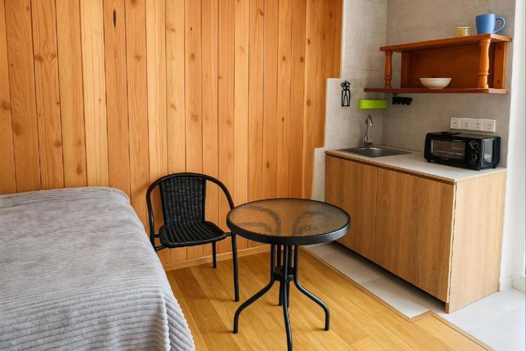 a small room with a table and a kitchen at Guest House Mari in Ureki