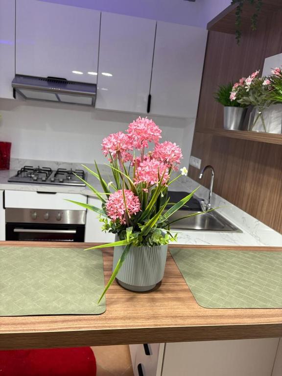 a vase of pink flowers sitting on a kitchen counter at Elégance & Confort in Rabat