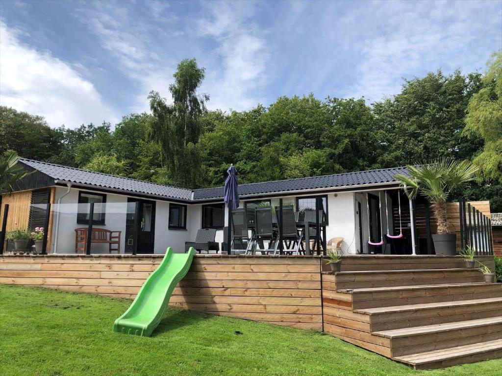 a house with a green slide in the yard at SJ314-Haderslev-Kelstrup-Norreskov-42 in Kelstrup Strand