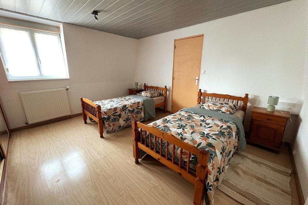 une chambre avec deux lits et une fenêtre dans l'établissement Maison - 3 chambres- 4 lits 3-6 personnes, à Beuvry